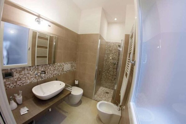A bathroom with a large sink, toilet, and shower area. - B&B Chez Moi (Bologna)