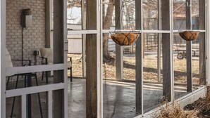 Una casa moderna con porche cubierto, ventanas amplias y cestas colgantes.