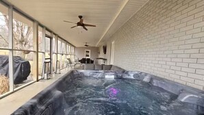 Un área de spa con hidromasaje, ventanas amplias y un ventilador de techo.