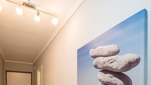 A hallway with a painting of stacked stones on a wall.