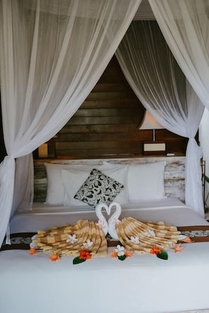 A bed with white bedding, a wooden headboard, and a canopy. - The Villa Dini Dnusa Lembongan (Lembongan Island)