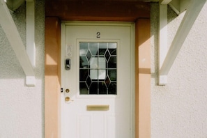 A white door with the number 2, a glass panel with a geometric pattern, and a small mail slot. - Inverness City Rooms (Inverness)
