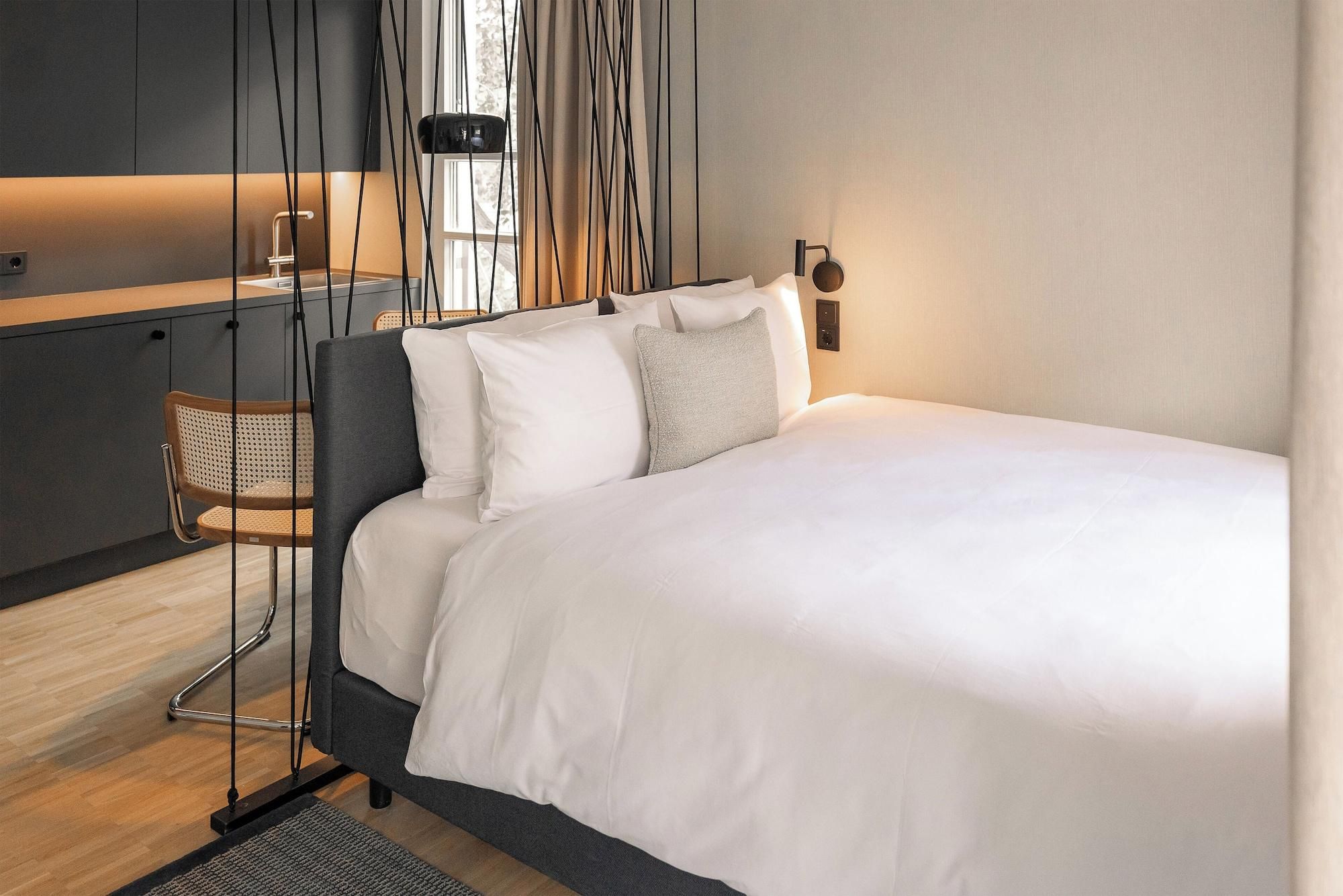 Een moderne slaapkamer met een bed, een stoel en een bureau.
