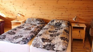 Una stanza con due letti singoli, ognuno con copriletto decorato e una lampada da comodino.