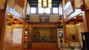 Een traditionele Japanse lobby met tatami vloeren, houten balken en shoji schermen.