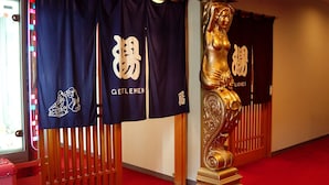 Een hal met roodgekleurd tapijt, blauwe banners met witte tekst, en een gouden beeldhouwstuk.