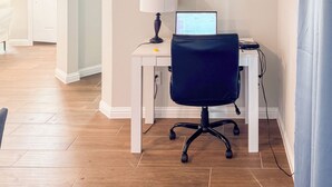 Ein moderner Arbeitsplatz mit Schreibtisch, Stuhl, Computer und Lampe.