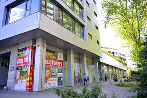 A modern building with large windows and a sign for a computer store. - Jessapart Hotel - Triton Park (Warsaw)