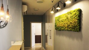 A hallway with a modern light fixture, a green textured wall, and a door labeled "SYY". - Jessapart Hotel - Triton Park (Warsaw)