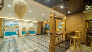 Un interior moderno con barra de madera, asientos con cojines azules y suelo de mármol.