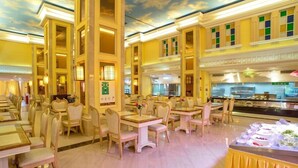Un restaurante espacioso con techos altos y un diseño de techo con motivos de nubes.