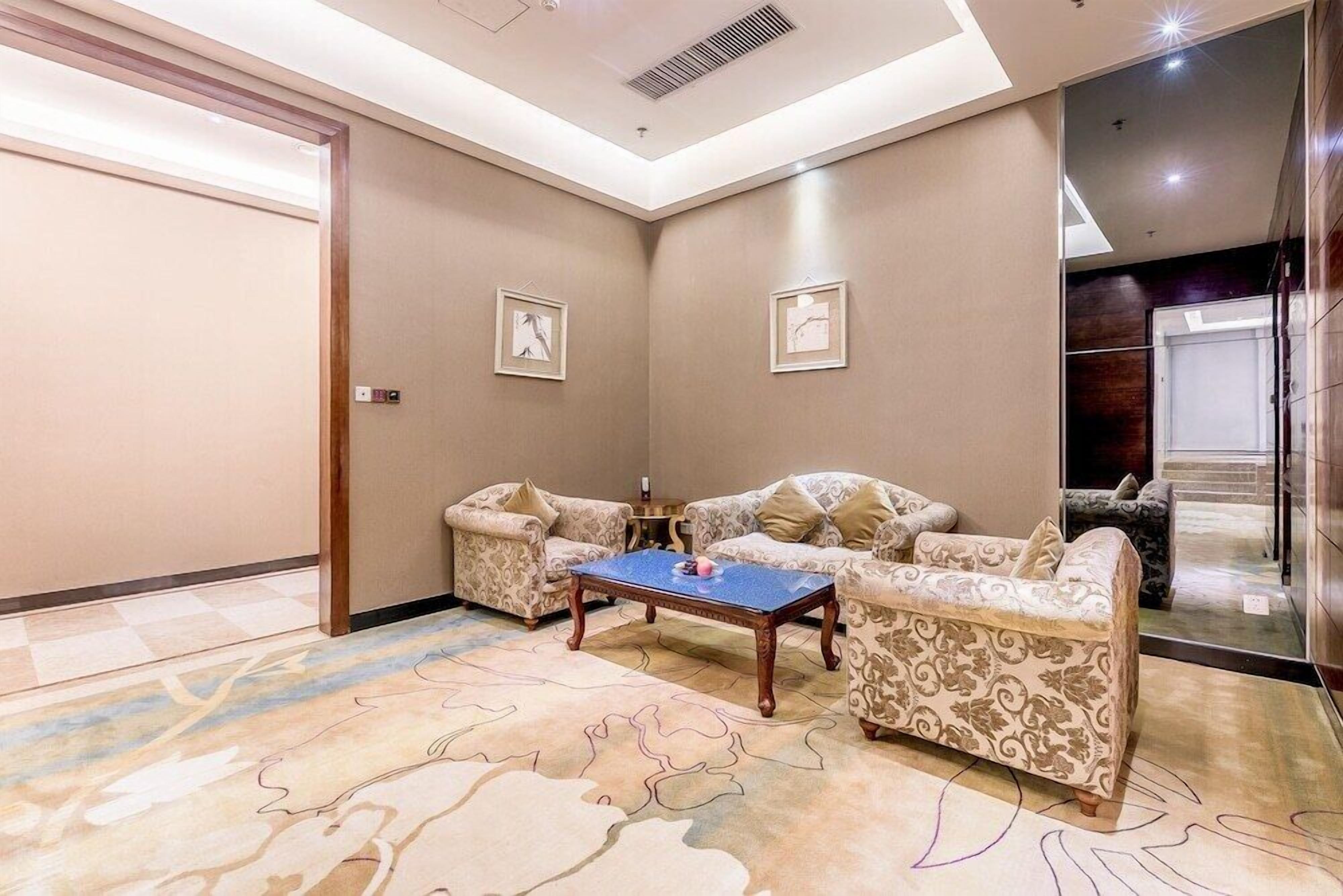 A room with a sofa set, a coffee table, and framed artwork on the walls.