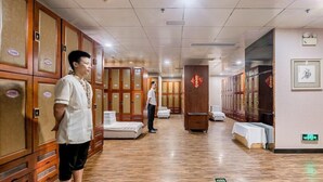 Un pasillo de hotel con taquillas de madera, un mostrador de recepción y un letrero direccional en el suelo.