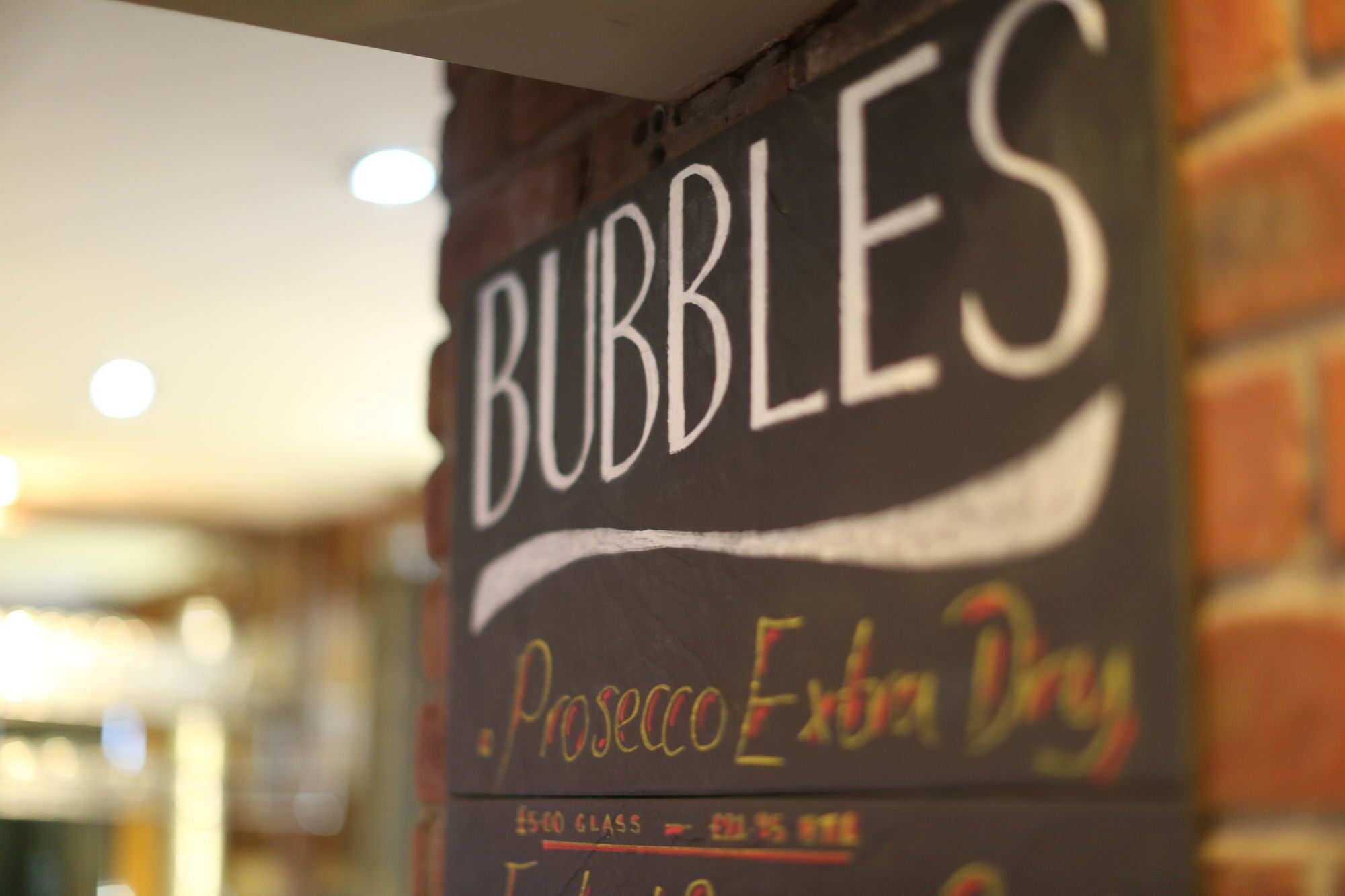 A chalkboard sign with the word "BUBBLES" and "Prosoco Extra Dry" written on it.
