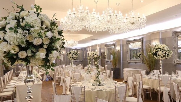 A banquet hall with round tables, white chairs, and chandeliers. - The Crown Hotel (Doncaster)