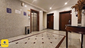 A hotel lobby with a marble floor, an elevator, and a reception desk. - Lazourd Palace Hotel Apartments (Taif)