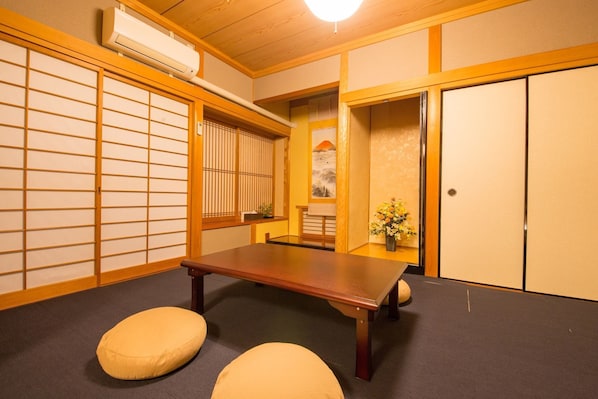 Een traditionele Japanse kamer met tatami vloerbedekking, een lage tafel en shoji schermen.
