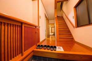 A wooden staircase leading to a room with a view of a traditional Japanese room. - Hiroshima Danbara Guesthouse by Exseed (Hiroshima)