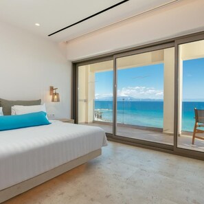 A bedroom with a large bed, a view of the sea, and a sliding glass door leading to a balcony. - Tsamis Zante Suites (Zakynthos)