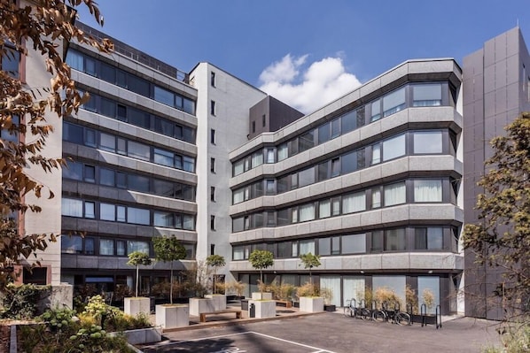 A modern multi-story building with a central courtyard featuring planters and a bike parking area. - Visionapartments Frankfurt Gutleutstraße (Frankfurt)