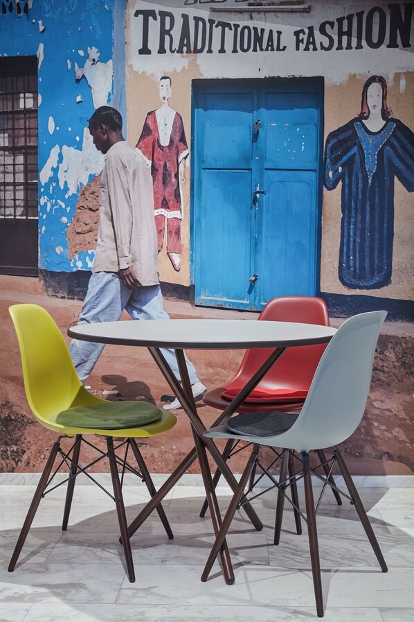 A table with four chairs in front of a mural depicting traditional fashion. - Visionapartments Frankfurt Gutleutstraße (Frankfurt)