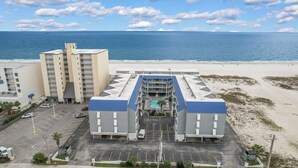 Hotel met zwembad, parkeerplaats en uitzicht op het strand.