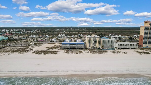 Een kustplaats met hotels aan het strand, zandstranden en een heldere lucht.