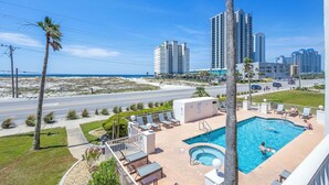 A hotel with a pool area, lounge chairs, and a view of the beach and ocean. - The East Beach Classic | Ground Floor Convenience (Gulf Shores)