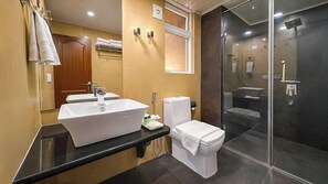 Uma casa de banho moderna com uma grande pia, sanita e zona de duche.