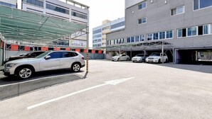 A parking area with a white SUV and several cars parked. - 1 Night 2 Days Hotel (Yangsan)
