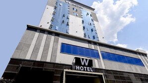 A hotel with a modern design, featuring a prominent 'W HOTEL' sign on the facade. - 1 Night 2 Days Hotel (Yangsan)