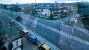 Eine Stadtansicht mit Straße, Gebäuden und bewölktem Himmel.
