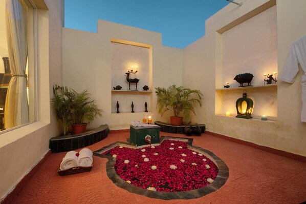 A serene indoor garden with a circular flower bed, potted plants, and a small fountain. - Aaram Baagh Agra On Pachar Group (Pushkar)