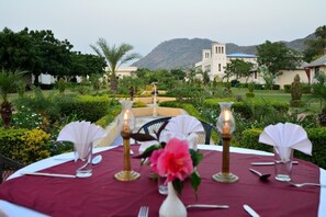 A table set for dining with a view of a mountainous landscape. - Aaram Baagh Agra On Pachar Group (Pushkar)