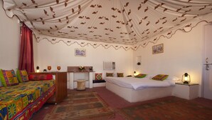 A room with a bed, a desk, a chair, a lamp, and a rug. - Aaram Baagh Agra On Pachar Group (Pushkar)