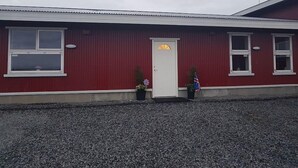 A red building with a white door and windows. - Skálatjörn Homestay (Selfoss)