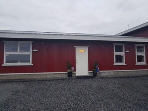 Un edificio rojo con puerta y ventanas blancas.