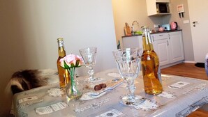A dining table with a floral centerpiece, two bottles, and a plate of chocolates. - Skálatjörn Homestay (Selfoss)