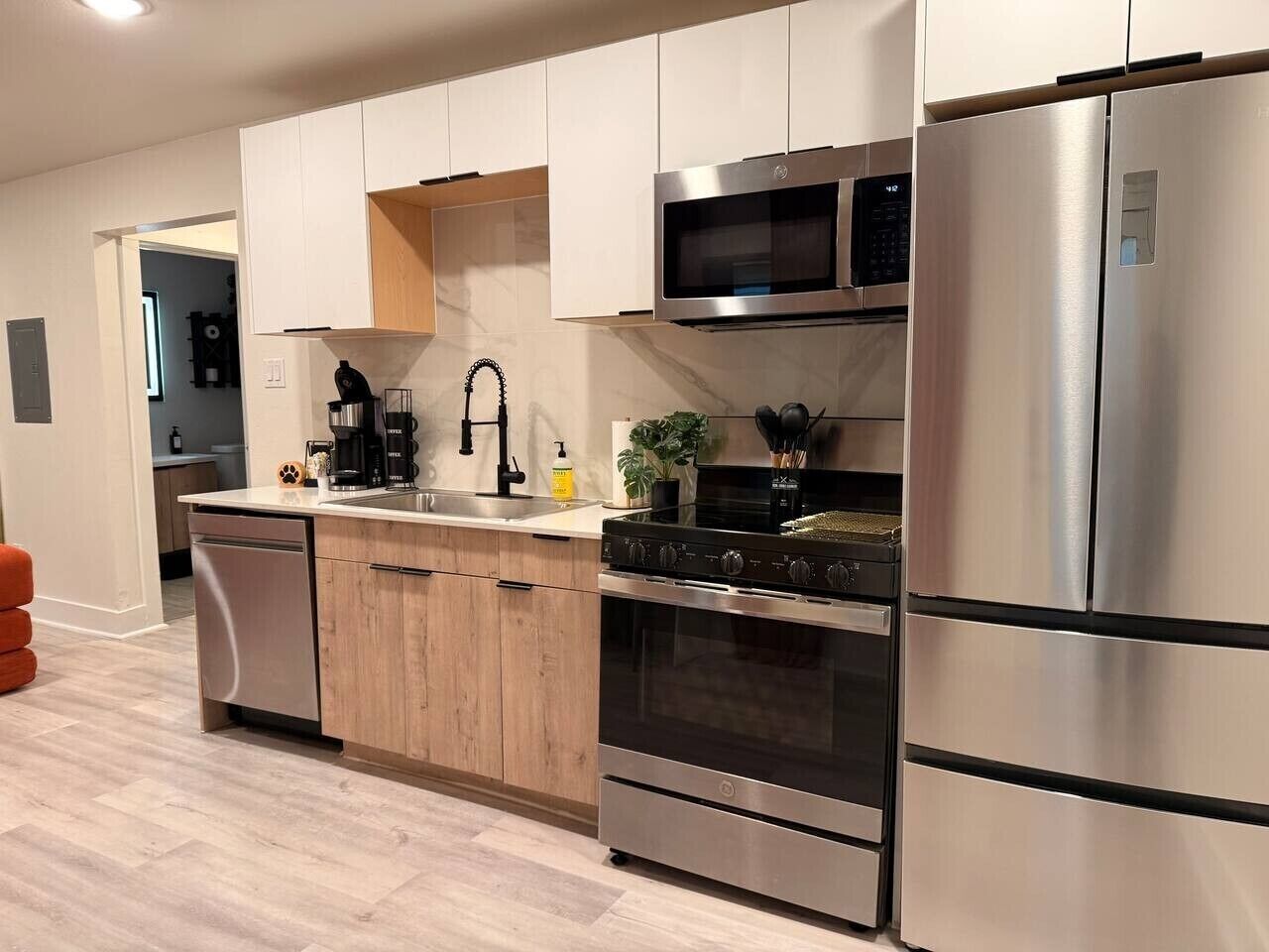 A modern kitchen with stainless steel appliances, a built-in oven, and a microwave.