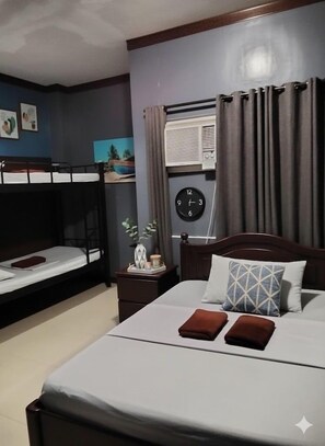 A hotel room with a single bed, a smaller bed, a nightstand with a clock, and a window with curtains. - Mactan-cebu Airport Budget Hotel (Lapu-Lapu)