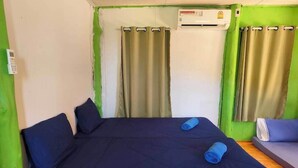 A room with a bed, a small sofa, and an air conditioning unit. - Banhalawee (Phang Nga)