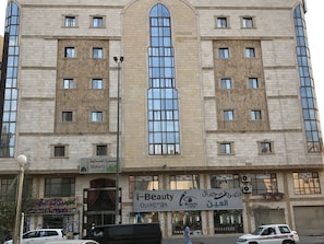 Un edificio a più piani con un'ampia finestra centrale e finestre più piccole su ogni piano.