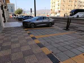 Una strada con un'auto parcheggiata e un autobus.