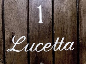 Un letrero de madera con el número 1 y el nombre 'Lucetta' escrito en él.