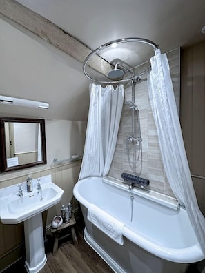 Un baño moderno con una bañera independiente, un lavabo con espejo y una zona de ducha con cabina de cristal.