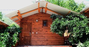 Una baita di legno con tetto spiovente, una porta in legno e una piccola finestra.