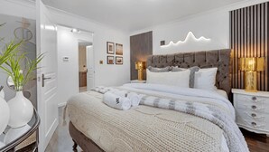 A modern bedroom with a large bed, bedside tables, and a nightstand. - Peaceful 2BR Flat |Near Becontree Stn.|Family|ST (Greater London)