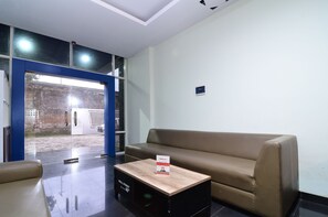 Un interior moderno con un sofá de cuero, una mesa de centro de madera y un vidrio que da al exterior.