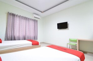 Une chambre d’hôtel avec deux lits, une télévision et un bureau.