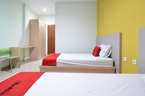 Una habitación de hotel con cama, escritorio, silla y armario.